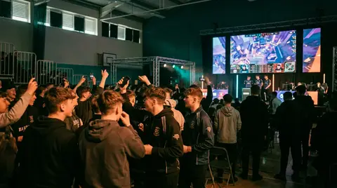 Illustration of a UK esports arena with crowd and big screens